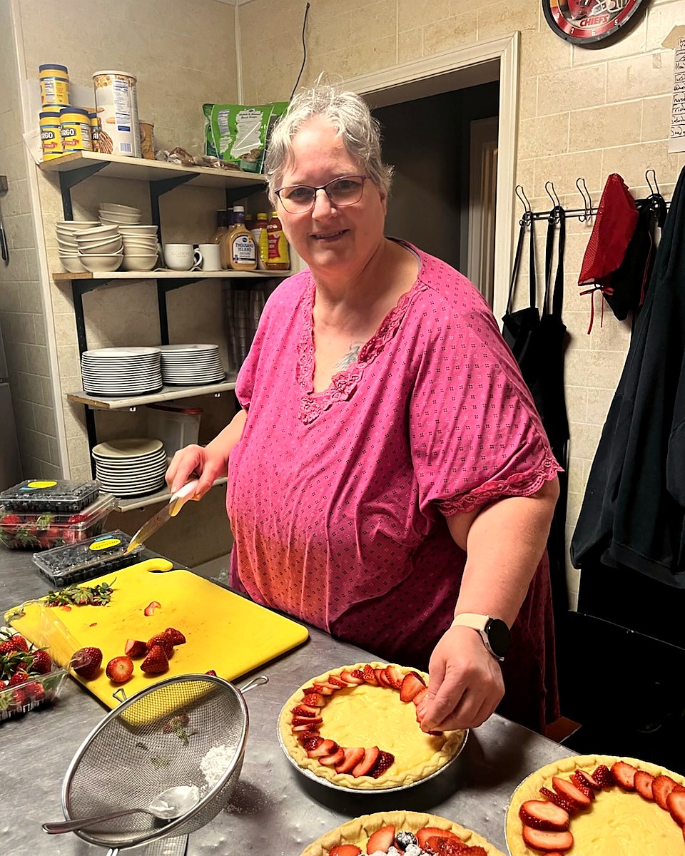 Kitchen staff decorating fresh strawberry pies