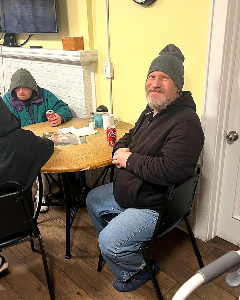 Resident smiling over coffee at the dining table